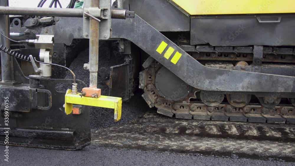 Paver applying asphalt on the highway.A huge heavy equipment flatten hot asphalt Paver applying asphalt on the highway.A huge heavy equipment flatten hot asphalt