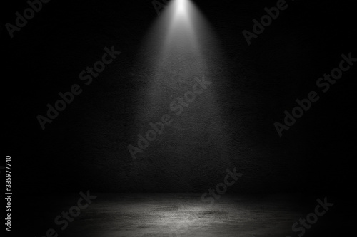 Empty space of Studio dark room black concrete wall and spotlight with concrete floor for showing product. © Angkana