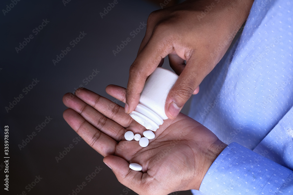  top view of of pill in hand isolated on black 