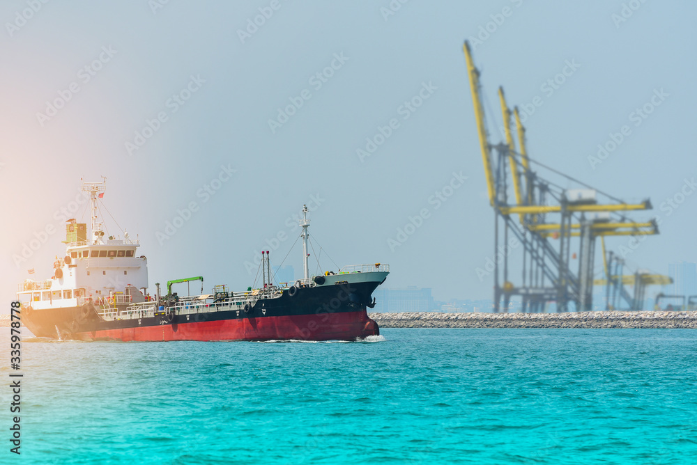 Oil and gas industry liquefied natural gas tanker LPG sailing in the sea on crane in port background.