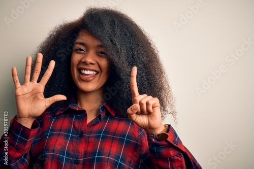 Young beautiful african american woman wearing casual shirt over isolated background showing and pointing up with fingers number six while smiling confident and happy. © Krakenimages.com