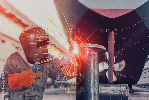 Close up worker welding ship repair, boat repair industry concept in shipyard on stern and propeller ship background on vintage tone.