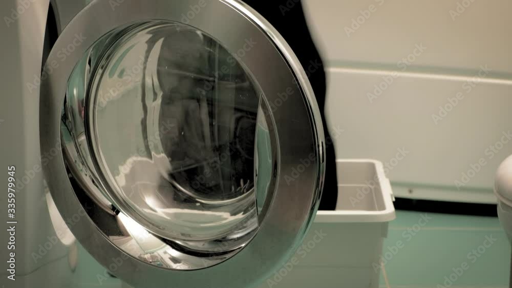 A woman sorts laundry before washing. A woman sorts laundry before washing.
