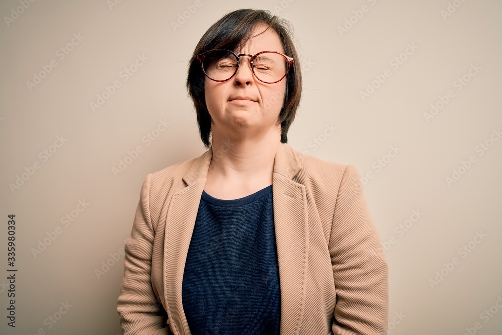 Young down syndrome business woman wearing glasses standing over isolated background with hand on stomach because nausea, painful disease feeling unwell. Ache concept.
