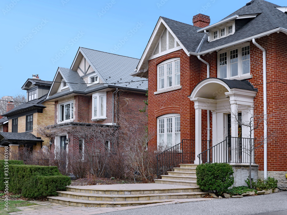 Residential street with detached two story houses with gables Residential street with detached two story houses with gables