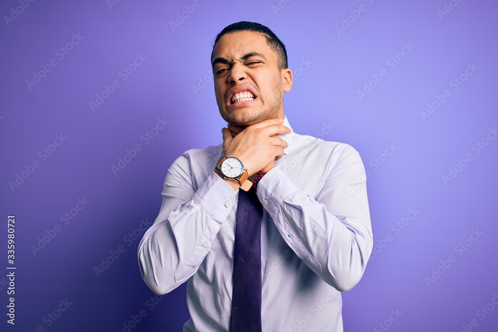 Young brazilian businessman wearing elegant tie standing over isolated purple background shouting suffocate because painful strangle. Health problem. Asphyxiate and suicide concept. Young brazilian businessman wearing elegant tie standing over isolated purple background shouting suffocate because painful strangle. Health problem. Asphyxiate and suicide concept.