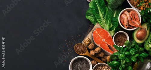 Food sources of omega 3 on dark background with copy space top view. Foods high in fatty acids including vegetables, seafood, nut and seeds. Health food fitness