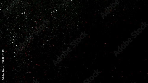 Falling flying Golden confetti. Abstract background with golden shiny sparkling sparkles. Particles of shiny dust sparkles. Flying and flickering particles of light. black background in 4K Loopable