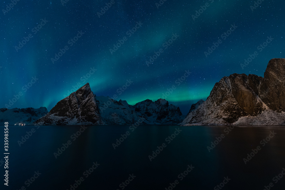 Aurora borealis or North light over Olstind mountain in Hamnoy village, Lofoten island in Norway, Scandinavia