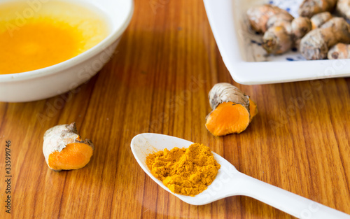 A table spoon of Pure Turmeric Haldi Powder spices . Turmeric with milk Indian cuisine recipe everyday can prevent digestion, stomach ulcers, diarrhoea and gastrointestinal infections.  Ayurveda .  photo