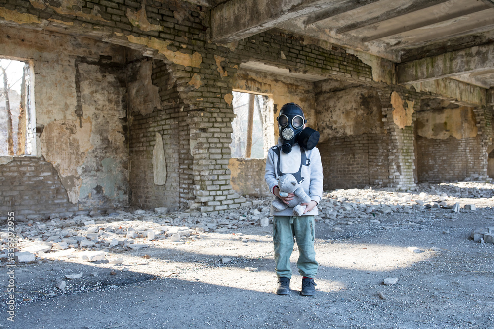 child in a gas mask in a destroyed building.