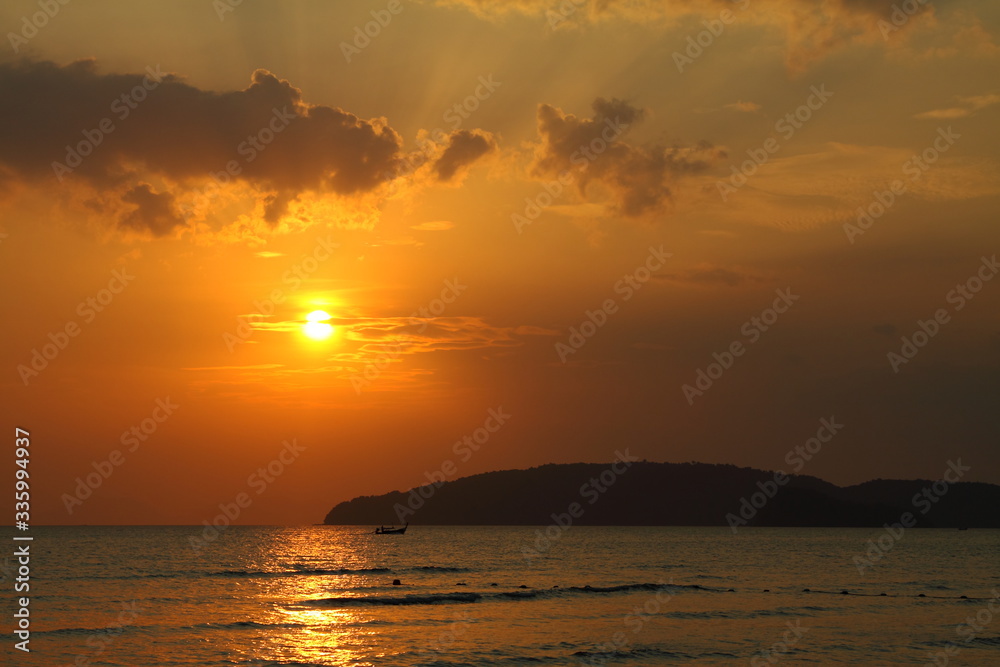 Sea view at the sunset. Beautiful evening coast.  View of the setting sun and clouds along the sea. Wallpaper and background.