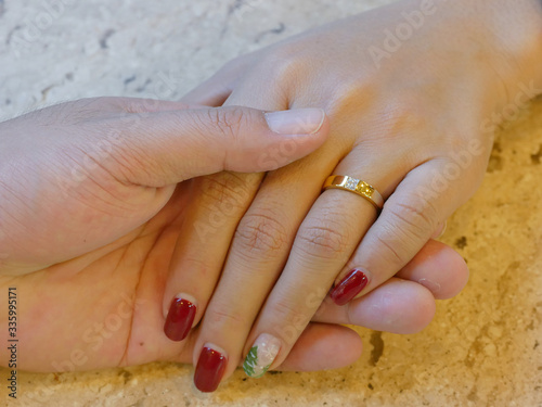 Close-up of photos of wedding couple wearing wedding rings