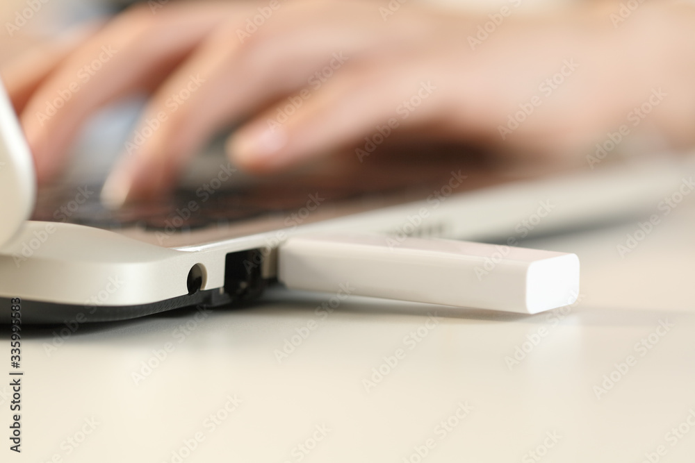 Woman hands working on laptop with plugged pendrive on foreground Woman hands working on laptop with plugged pendrive on foreground