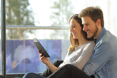 Happy couple reading book on an ebook reader