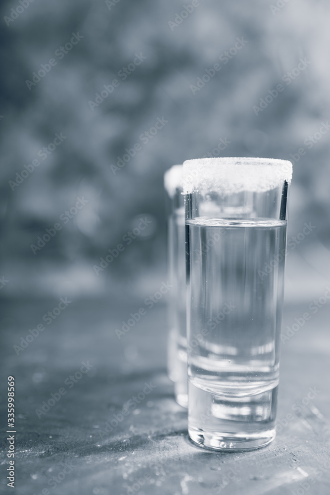 Tequila shots on the dark rustic background. Selective focus. Shallow depth of field.