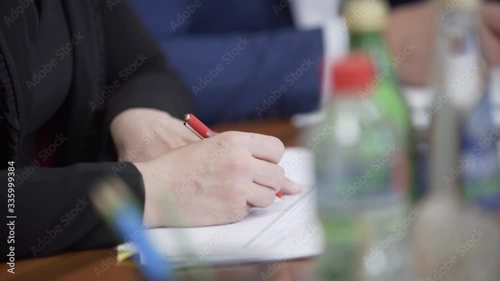 Female hand holding pen and writing to do list or business data with pen at notebook dairy. Hand writing business report, make note on paperwork document on office desk in corporate meeting room. Female hand holding pen and writing to do list or business data with pen at notebook dairy. Hand writing business report, make note on paperwork document on office desk in corporate meeting room.