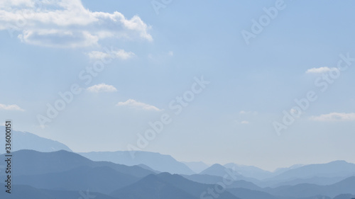 Weite Landschaft mit zum Horizont hin verschwimmenden Bergen und Hügeln © EvaRuth