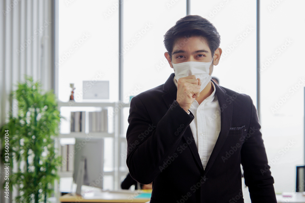Young Asian businessman is cough and wearing a mask at workplace to prevent the corona virus outbreak Young Asian businessman is cough and wearing a mask at workplace to prevent the corona virus outbreak
