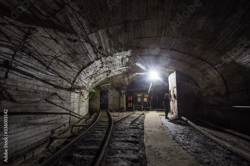 Underground gold mine shaft tunnel drift with rails and light