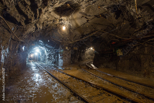Underground gold mine tunnel with rails two ways and light