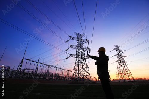 Electricity workers and pylon silhouette, Power workers at work