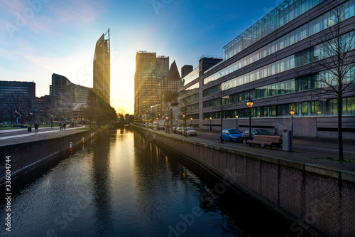 View of The Hague sunrise, early morning skyline reflected on the calm canal's water, Netherlands