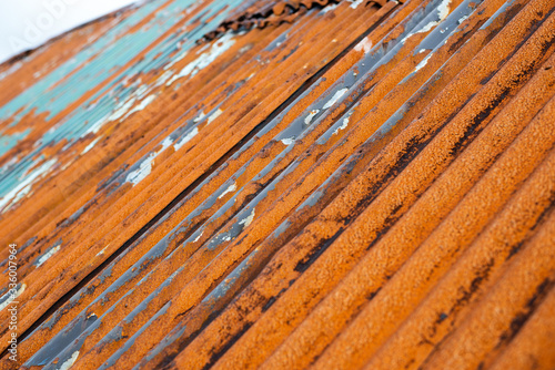 Rusty metal roof with damaged elements. Closeup