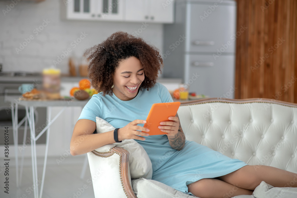 Young woman with tablet reclining on a couch at home. Young woman with tablet reclining on a couch at home.