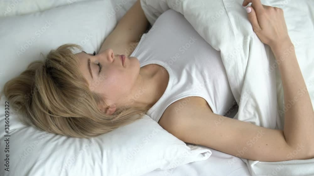 Successful woman waking up in cozy white bed, enjoying morning and her life Successful woman waking up in cozy white bed, enjoying morning and her life