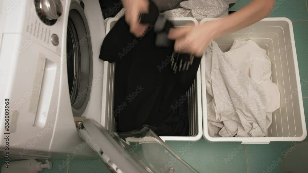 A woman sorts laundry before washing.