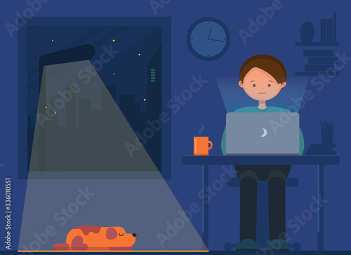 Freelancer working at night. Remote work. Young man and dog sitting in the room with laptop, surfing internet, networking. Programmer, designer, writer working at home.