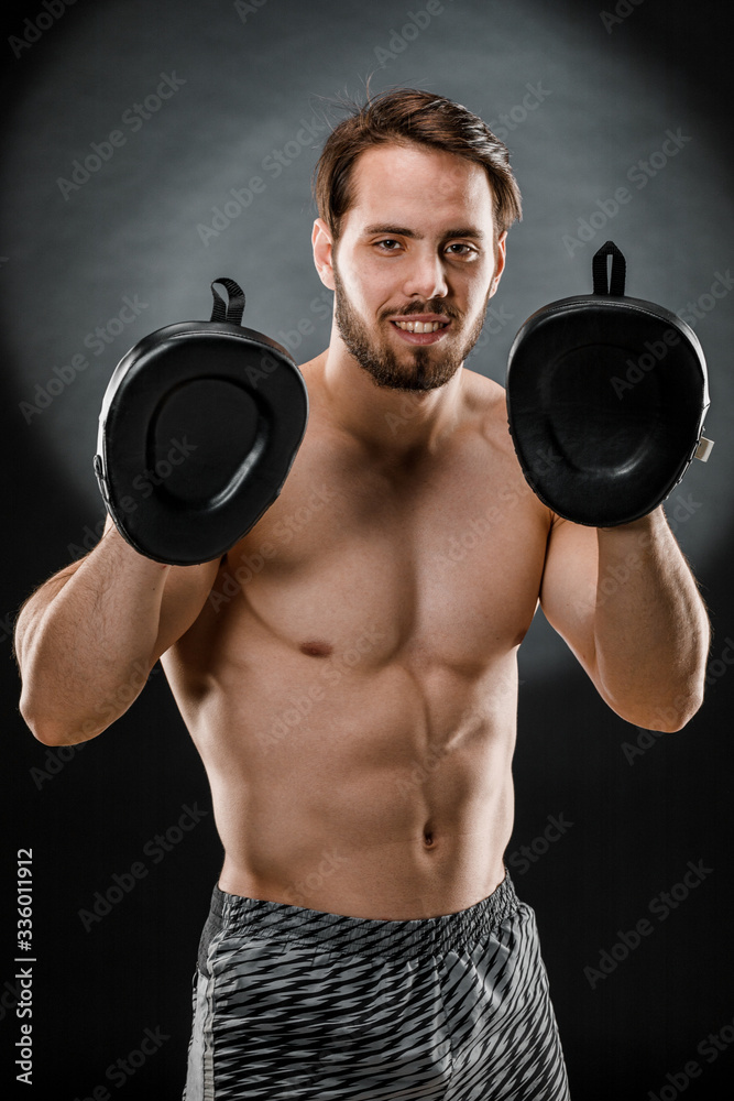 The boxer is a fighter, looking angrily at the camera. Young Caucasian male fitness model isolated on black background The boxer is a fighter, looking angrily at the camera. Young Caucasian male fitness model isolated on black background