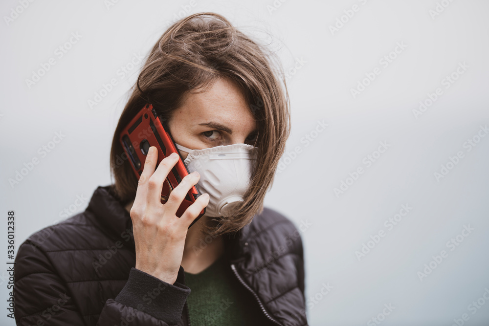 a woman talking on the phone with coronavirus mask a woman talking on the phone with coronavirus mask