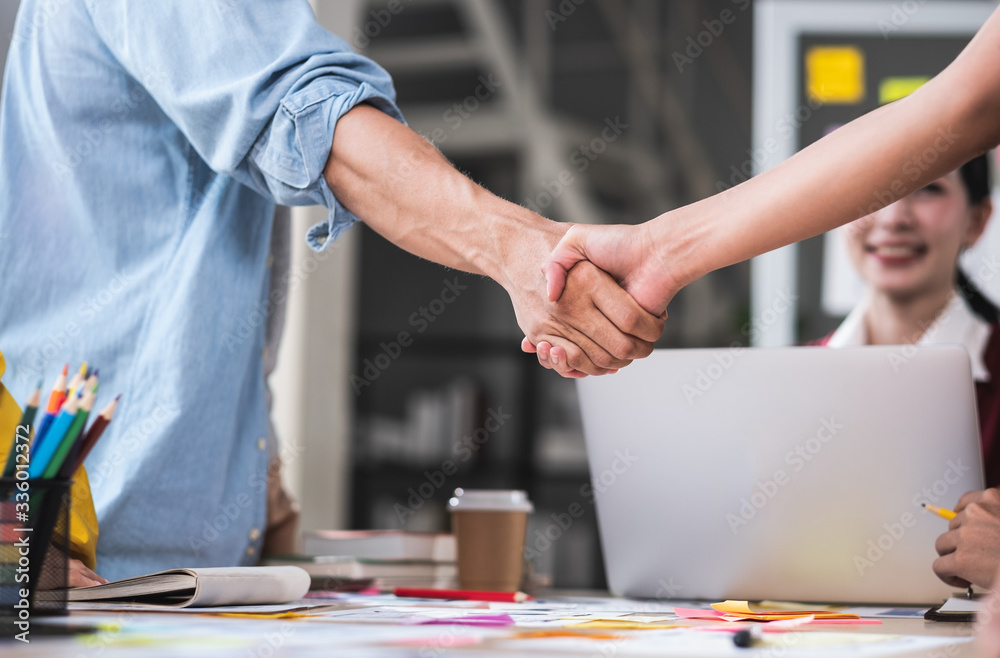 close up handshaking of ux developer and ui designer deal with contract partnership over meeting table in boardroom at modern office.congratulation handshaking for job promotion