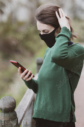 a woman talking on the phone with coronavirus mask