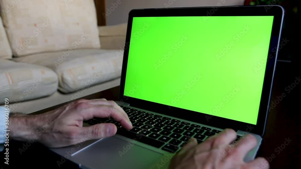 Unrecognizable man working at home with a green screen computer Unrecognizable man working at home with a green screen computer