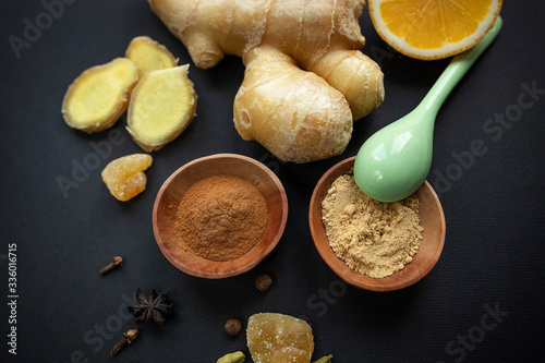Ginger root, cloves, spices on a black background. Healthy food concept, virus protection, increased immunity during coronavirus quarantine, super nutrition. Selective focus.