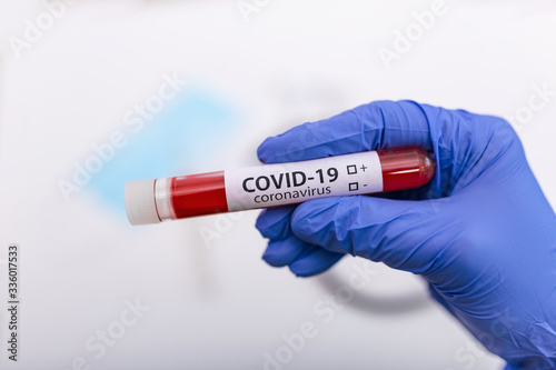 Coronavirus Covid 19 infected blood sample in sample tube in hand of scientist doctor biohazard protection clothing in coronavirus covid 19 research laboratory, Coronavirus Covid-19 vaccine research