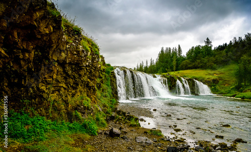 Pretty Iceland waterfall with fishermen fishing