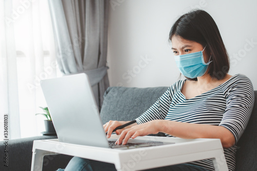woman wearing face mask working from home