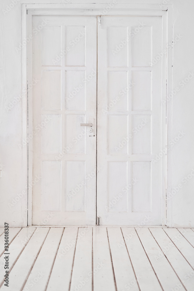 Old-style white wooden door. interior apartment. Wooden floor made of planks Old-style white wooden door. interior apartment. Wooden floor made of planks