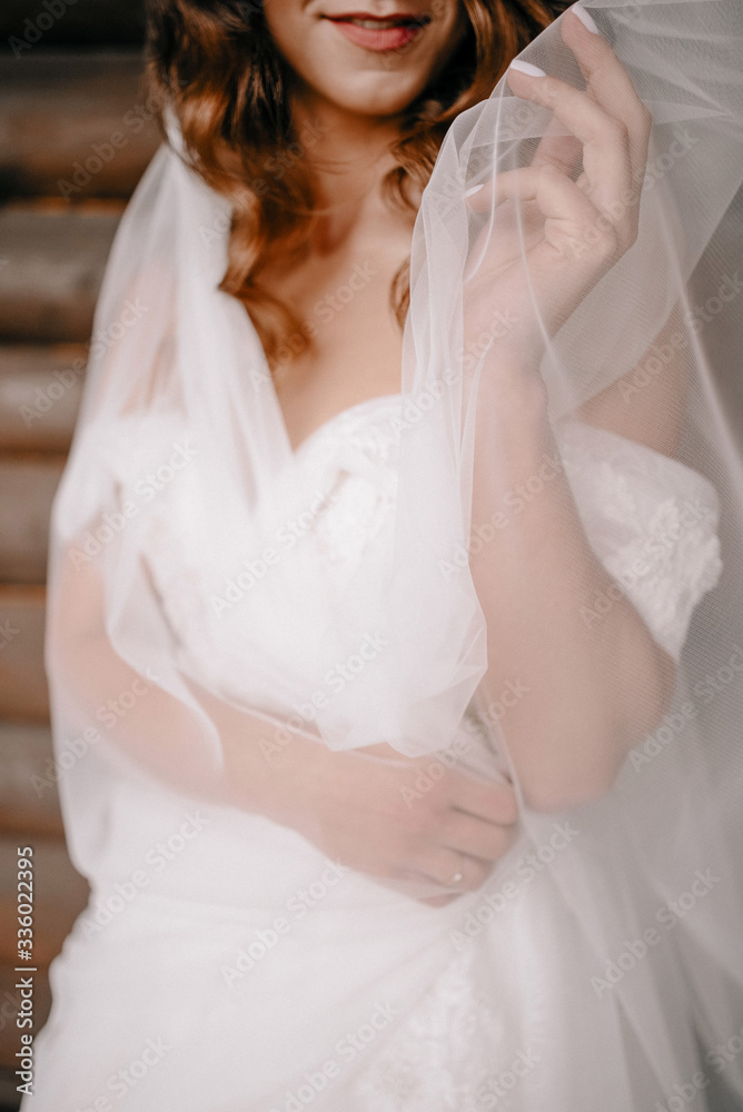 Bride in a white dress with tender freckled hands. Female hands with a wedding ring. Shiny white beautiful dress. Detail of a bride dress closeup.