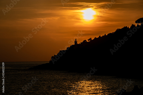 silhouette of a lighthouse in Circeo national park at sunset. Latina, Lazio, Italy