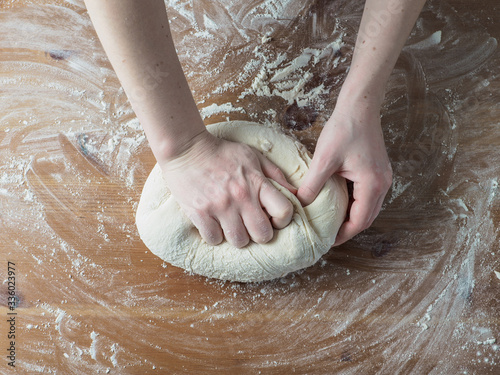 Woman hands kneading dough for bread.