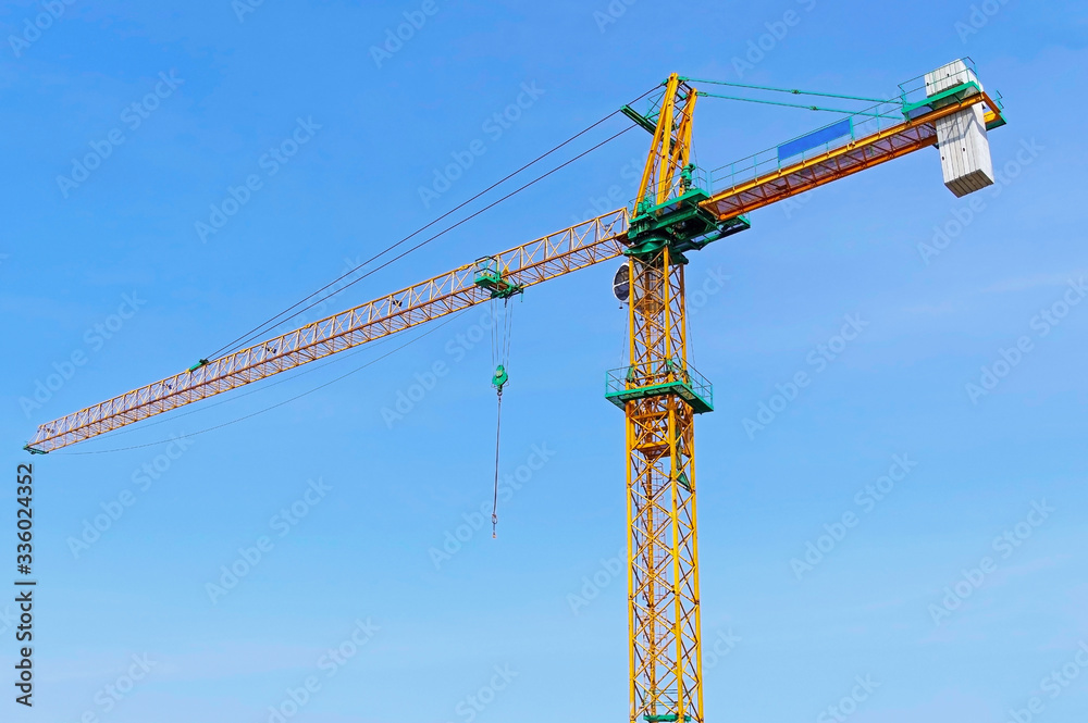yellow construction crane tower on background sky
