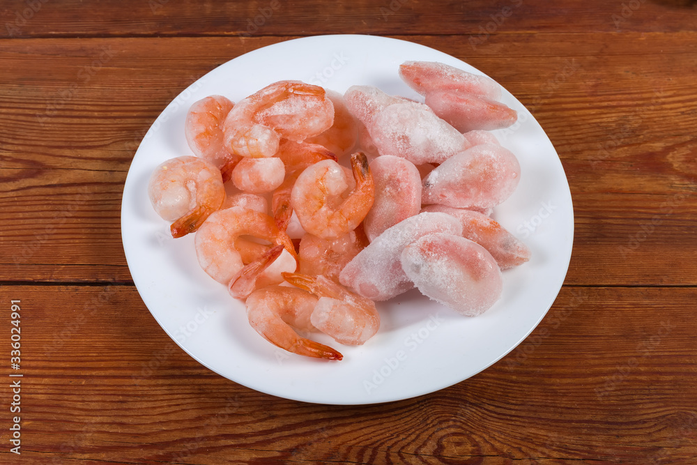 Prawn tails and usual shrimps in ice glazing on dish Prawn tails and usual shrimps in ice glazing on dish