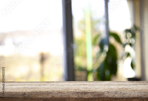 Wooden table top on a window glass blur with a view on the background. Street. To display product montage