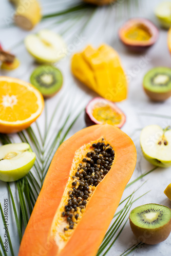 Exotic fruits and tropical leaves on table photo