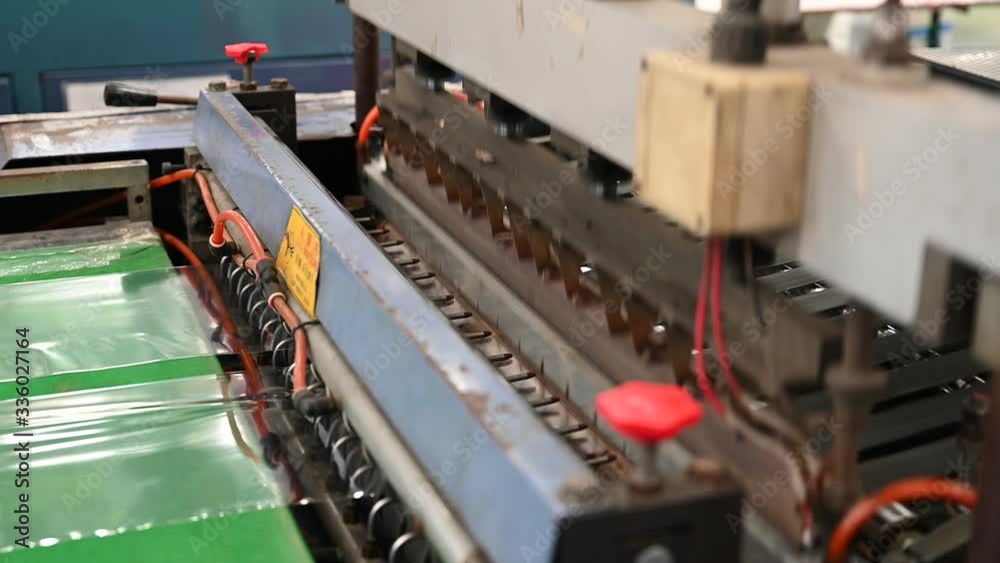 The operation of the side seal opp plastic bag cutting machine Closeup at the seal and cutting knife set in the concept of saving the world and the environment. The operation of the side seal opp plastic bag cutting machine Closeup at the seal and cutting knife set in the concept of saving the world and the environment.